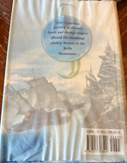 Book cover with a scenic illustration and text on a wooden surface